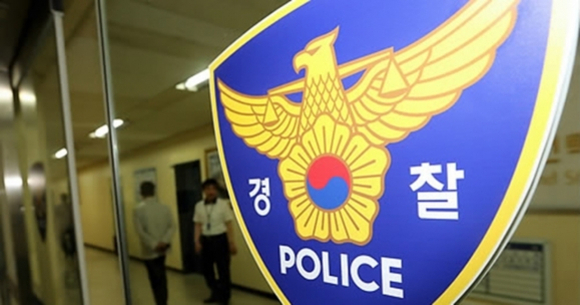 유리문에 부착된 대한민국 경찰 로고와 그 뒤로 복도에 서 있는 사람들