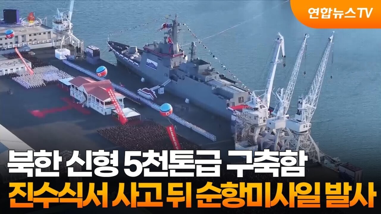 북한의 신형 5천톤급 구축함이 항구에 정박해 있으며, 주변에는 많은 인파와 군중이 모여 있다. 화면 상단 오른쪽에는 '연합뉴스TV' 로고가 있고, 하단에 '북한 신형 5천톤급 구축함 진수식서 사고 뒤 순항미사일 발사'라는 자막이 표시되어 있다.