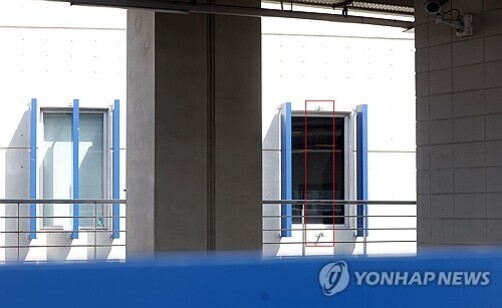 회색 콘크리트 건물 외벽에 파란 창문 두 개가 보이고, 오른쪽 창문에는 빨간 테이프가 X자 모양으로 붙어 있다. 하단에는 'YONHAP NEWS' 로고가 있다.