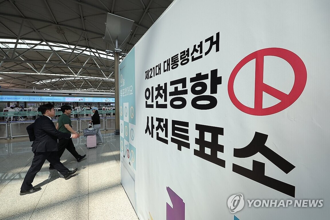 인천공항 내부에 제21대 대통령선거 인천공항 사전투표소 안내판이 설치되어 있고, 사람들이 투표소 방향으로 걷고 있다.