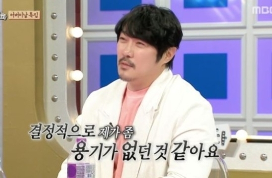 남성이 방송 스튜디오에서 앉아 있고, 화면 아래에 '결정적으로 제가 좀 용기가 없던 것 같아요'라는 자막이 표시되어 있다.