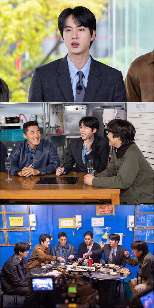 여러 남성이 식당에서 함께 앉아 음식을 먹고 대화를 나누며 즐거운 시간을 보내는 모습이다. 한 명은 정장을 입고 있고, 모두가 밝게 웃거나 음식에 집중하고 있다.