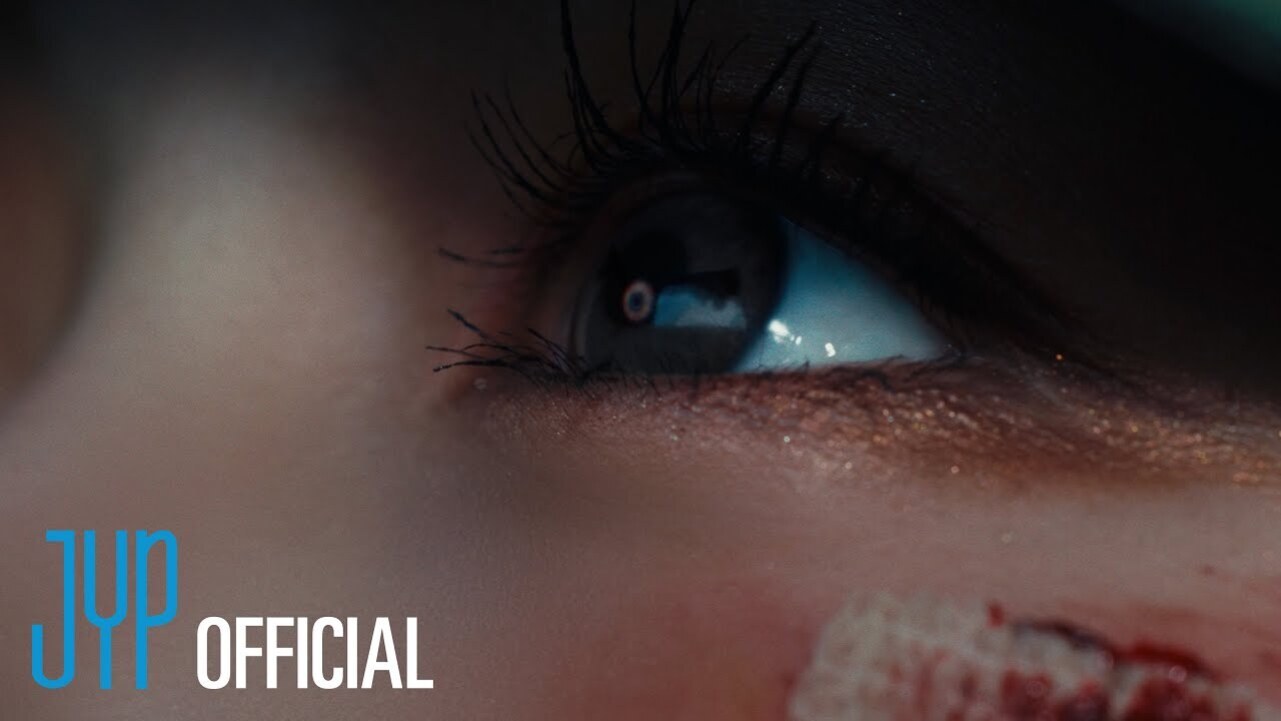 눈을 클로즈업한 이미지로, 아래쪽 피부에 상처가 있으며 JYP OFFICIAL 로고가 왼쪽 하단에 있다.