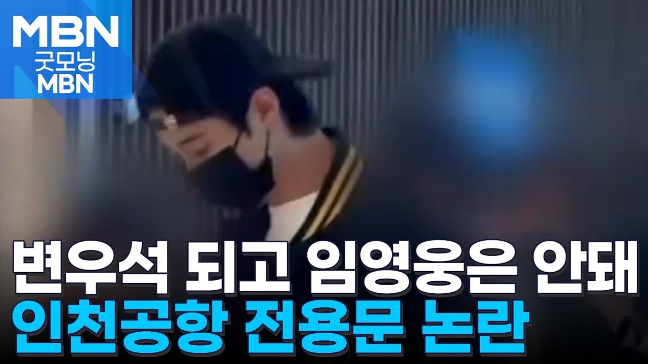 한 남성이 검은 마스크와 모자를 착용하고 고개를 숙이고 있는 모습. 좌측 상단에 'MBN 굿모닝 MBN' 로고가 있으며, 하단에는 '변우석 되고 임영웅은 안돼 인천공항 전용문 논란'이라는 뉴스 자막이 있다.