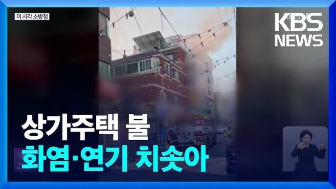 상가주택에서 불이 나 화염과 연기가 치솟고 있는 모습을 담은 KBS 뉴스 화면, 오른쪽 하단에는 수어 통역사가 있다.