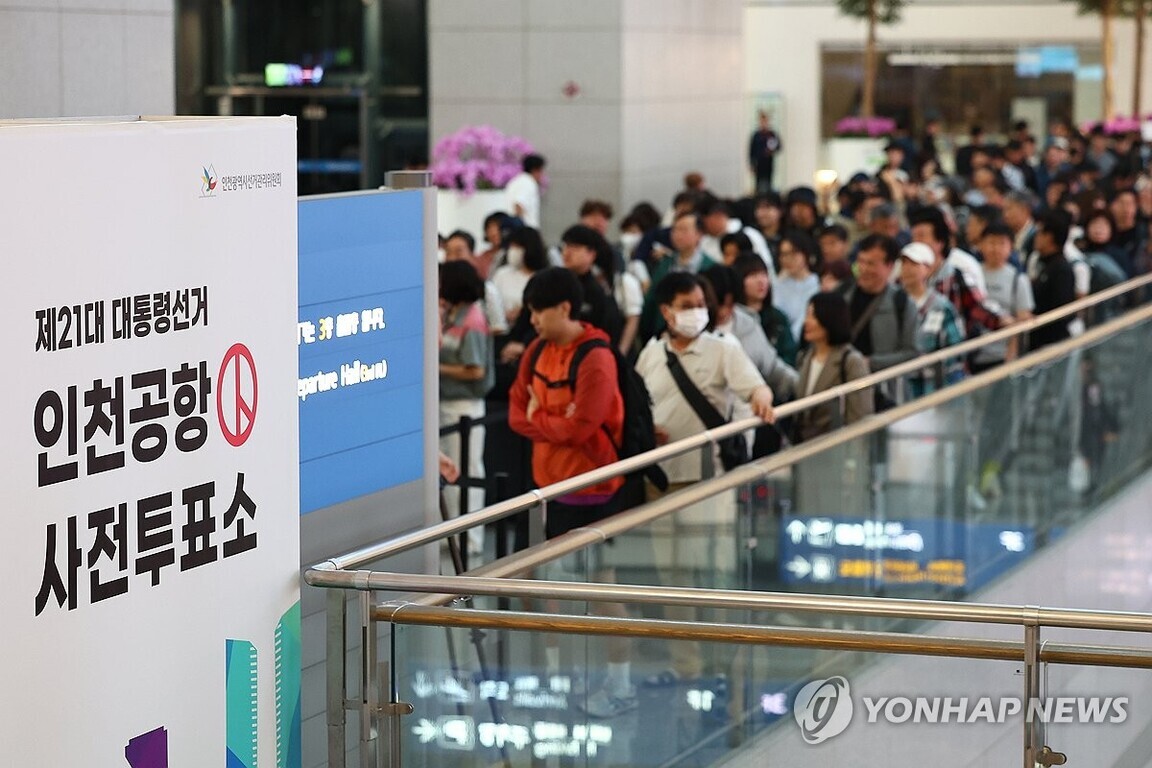 인천공항 사전투표소 안내판 앞에 많은 사람들이 줄을 서 있는 모습