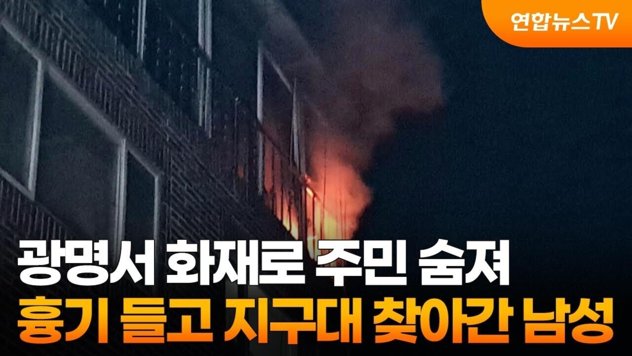 밤에 아파트 건물에서 불길과 연기가 치솟고 있으며, 화면 상단에는 '연합뉴스TV' 로고가 있고 하단에는 '광명서 화재로 주민 숨져 흉기 들고 지구대 찾아간 남성'이라는 자막이 있다.