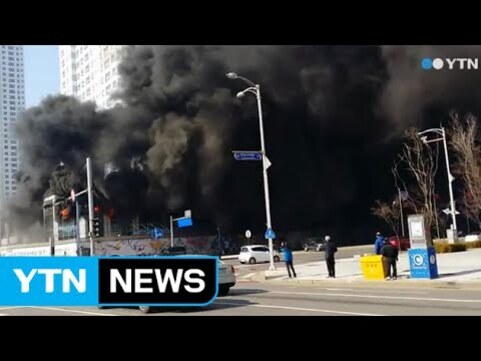 도심의 건물에서 검은 연기가 심하게 피어오르고 있으며, 인근에 사람들이 서 있고 YTN 뉴스 로고가 보인다.