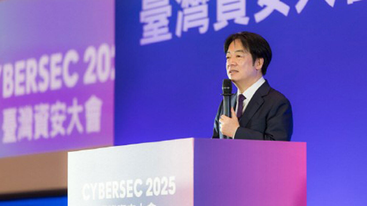 정장을 입은 남성이 마이크를 들고 'CYBERSEC 2025'라는 문구가 적힌 단상에서 연설하고 있다. 배경에는 대형 스크린에 한자와 영어로 된 글자가 보인다.