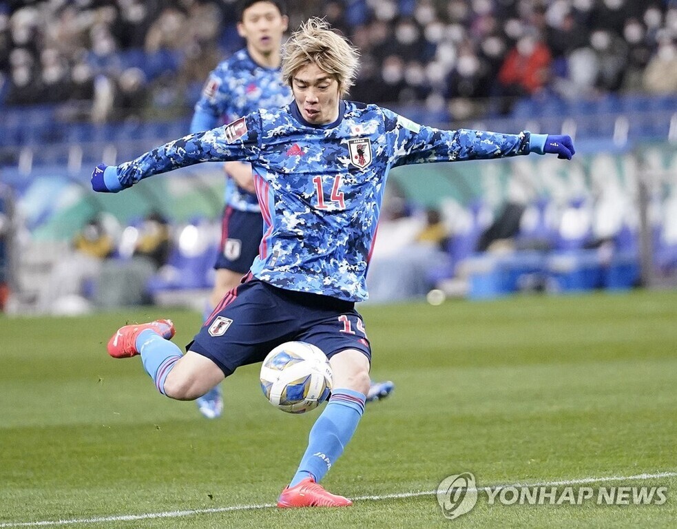 일본 축구 대표팀 유니폼을 입은 선수가 경기 중 공을 강하게 차는 모습