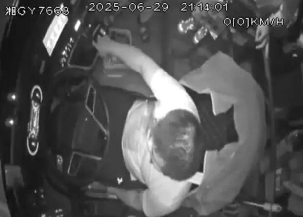 야간에 차량 내부를 위에서 촬영한 흑백 CCTV 영상으로, 한 남성이 운전석에 앉아 오른손을 대시보드 쪽으로 뻗고 있다. 화면 상단에는 날짜와 시간이 표시되어 있다.