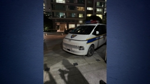 아파트 단지 내에 정차된 경찰 순찰차가 밤에 보인다.