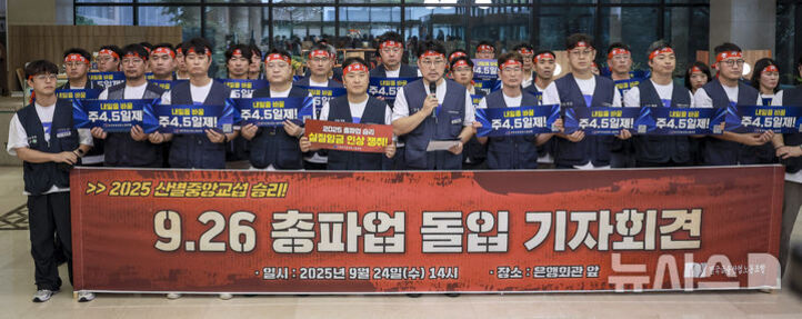 여러 명의 노동자들이 빨간 머리띠를 두르고 '9.26 총파업 돌입 기자회견'이라는 문구가 적힌 대형 현수막 앞에 서 있다. 일부는 파란색 피켓을 들고 있으며, 회견은 실내에서 진행되고 있다.