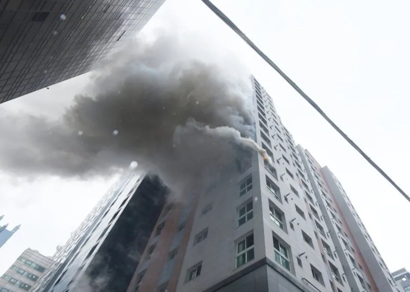 고층 건물의 창문에서 연기가 많이 나오는 화재 현장
