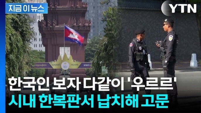 캄보디아 국기와 기념탑 앞에 두 명의 경찰이 서 있고, 뉴스 자막에는 '한국인 보자 다같이 우르르' 시내 한복판서 납치해 고문이라는 문구가 있다.