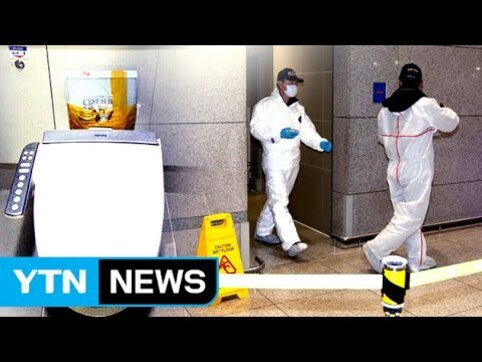 방역복을 입은 두 명의 인원이 실내 공공장소에서 소독 작업을 하고 있으며, 바닥에는 미끄럼 주의 표지판이 세워져 있다. 화면 왼쪽 아래에 YTN NEWS 로고가 보인다.