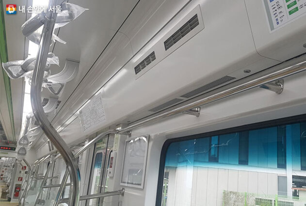 지하철 내부의 천장과 손잡이, 창문 및 에어컨 송풍구가 보이는 모습