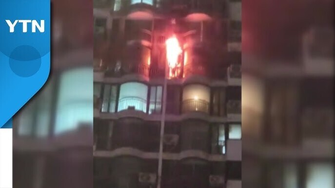 고층 아파트의 발코니에서 불길이 크게 치솟는 화재 현장