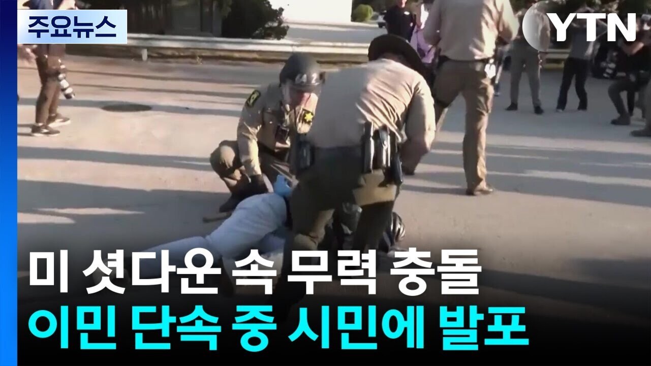 경찰관들이 도로 위에 한 시민을 제압하고 있으며, 주변에는 다른 사람들이 상황을 지켜보고 있다. 화면 좌측 상단에는 '주요뉴스'라는 문구가 있고, 하단에는 '미 셧다운 속 무력 충돌 이민 단속 중 시민에 발표'라는 자막이 있다.