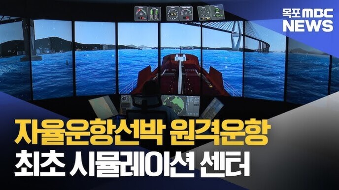 여러 개의 큰 화면에 바다와 선박이 보이는 시뮬레이션 센터 내부에서 한 사람이 조종석에 앉아 있으며, 상단에는 '목포 MBC NEWS' 로고가 있고 하단엔 '자율운항선박 원격운항 최초 시뮬레이션 센터'라는 문구가 있다.