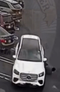 흰색 벤츠 SUV 차량이 주차장에 비스듬히 주차되어 있고, 오른쪽 뒷바퀴가 빠져 있다.