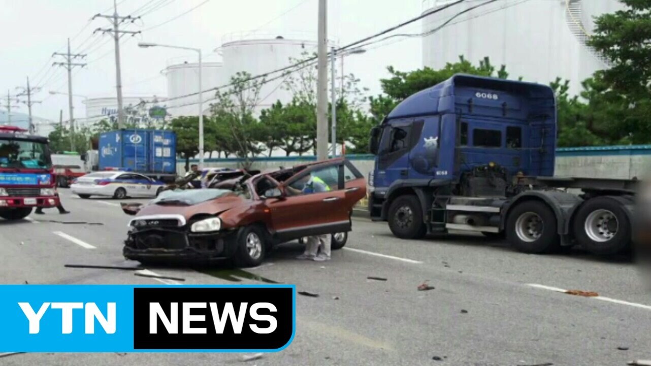 도로 위에서 대형 트럭과 승용차가 충돌한 교통사고 현장으로, 파손된 차량들과 출동한 소방차와 경찰차가 보인다.