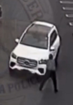 흰색 SUV 차량 앞에 한 사람이 서 있는 모습